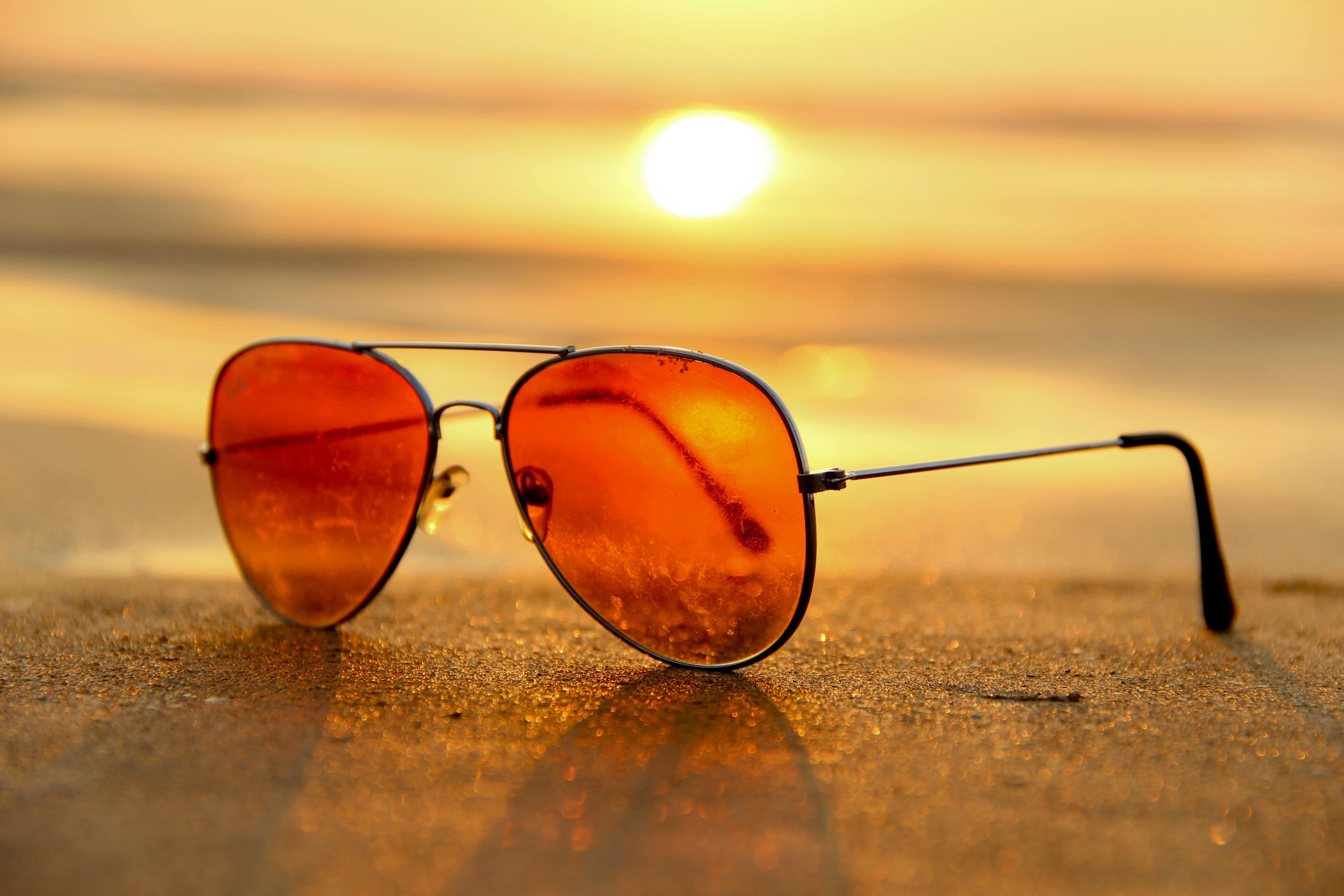 Aviator sunglasses on beach at golden hour sunset